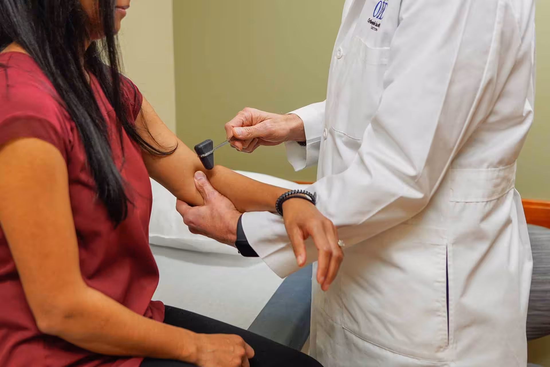 A close of a doctor examining a female patients elbow