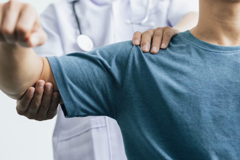 A close up of a doctor examining a patients shoulder